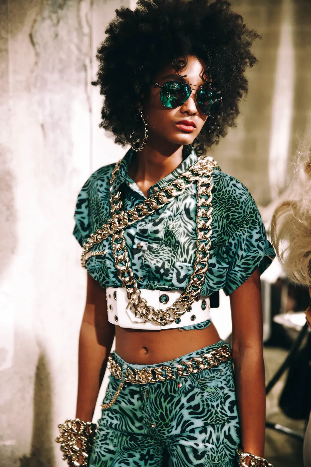 Model with an afro and sunglasses in green brocade